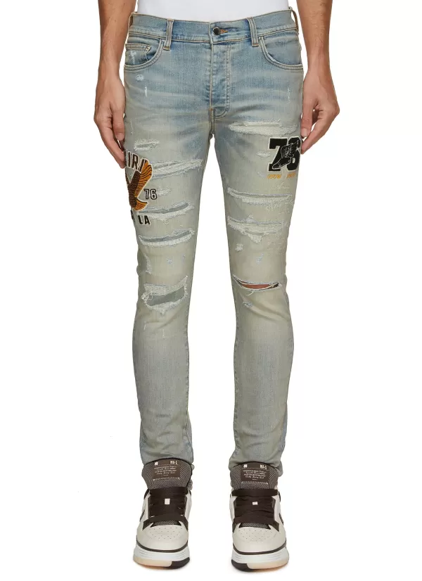 Pants>AMIRI Varsity Eagle Logo Distressed Skinny Jeans